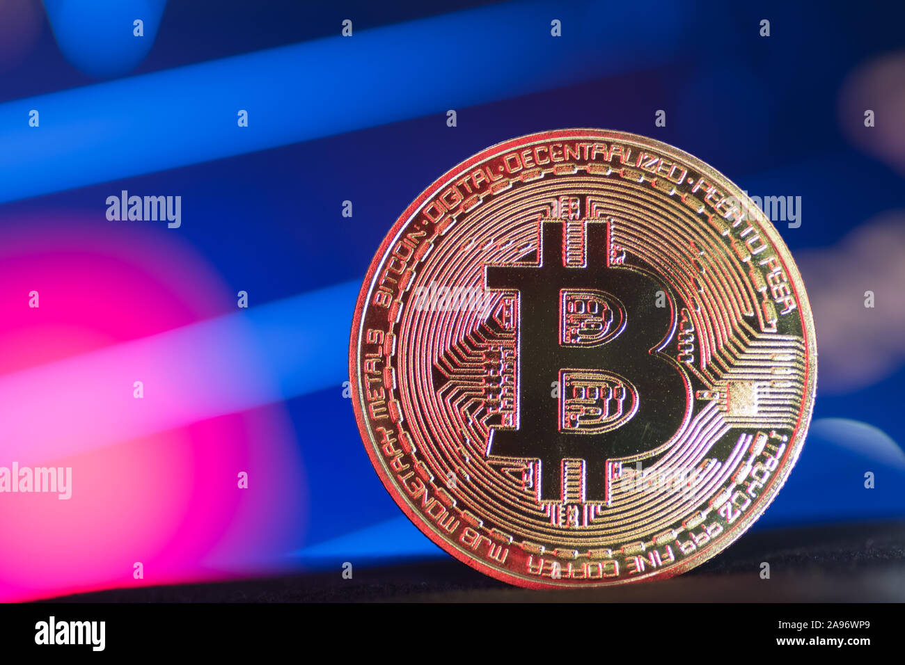 Golden Bitcoin on neon lit background Stock Photo