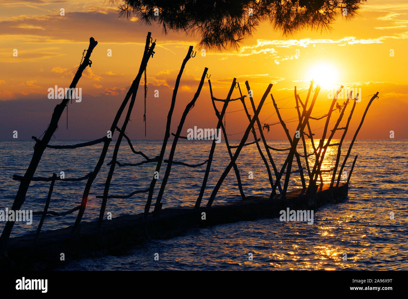 Old pier at sunset time in Savudrija, a Croatian coastal town. Travel, tourism and vacation. Stock Photo