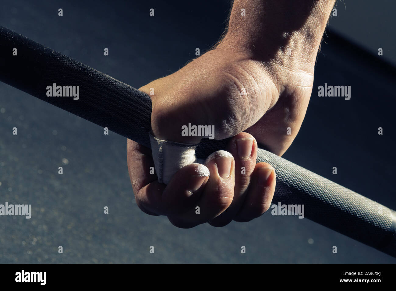 Closeup of man's right hand gripping a barbell with a hook grip Stock Photo