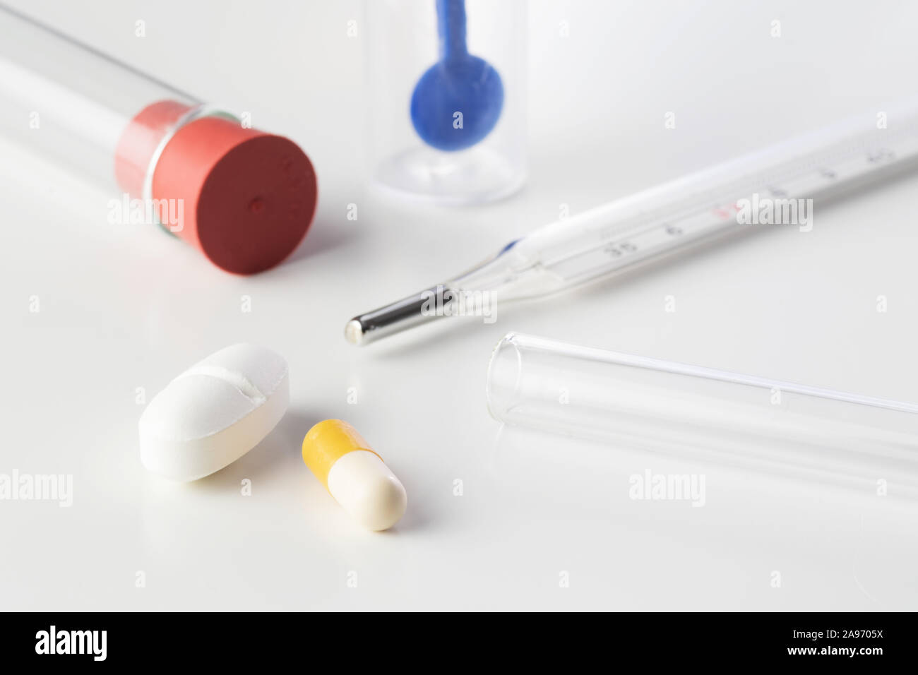 Pills with mercury thermometer, glass tubes and stool test sampler