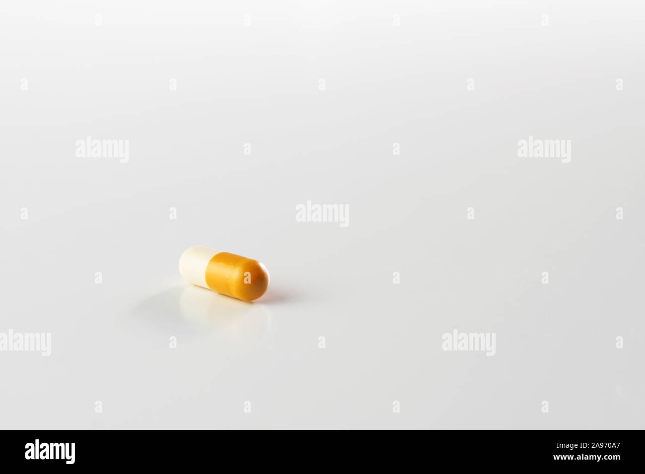 Closeup of yellow and white capsule pill isolated on white background