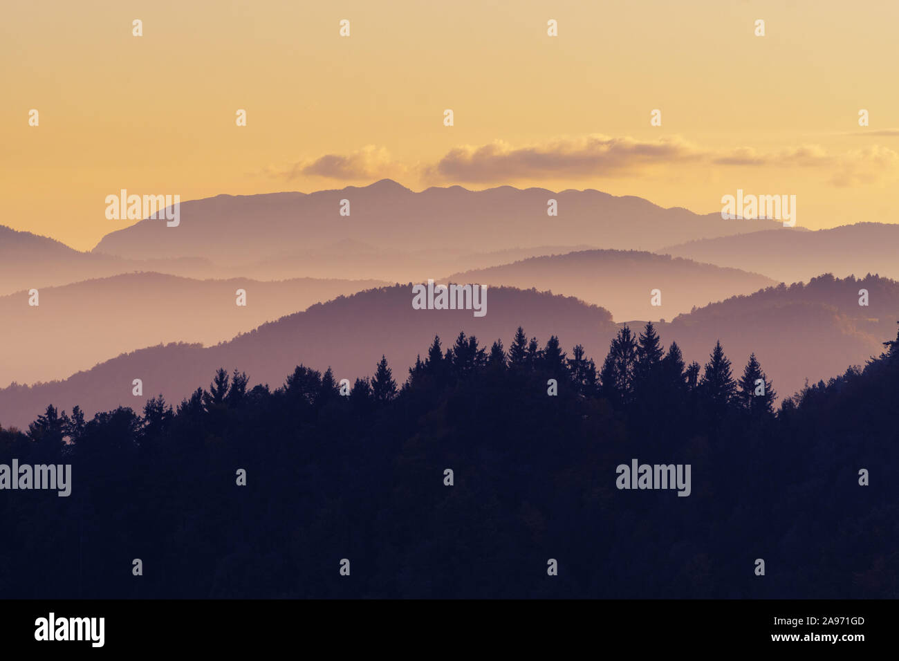 Beautiful pink and orange color nuances of twilight sky, hills and forests after sunset. Travel, hiking, atmosphere, magical nature and forestry. Stock Photo