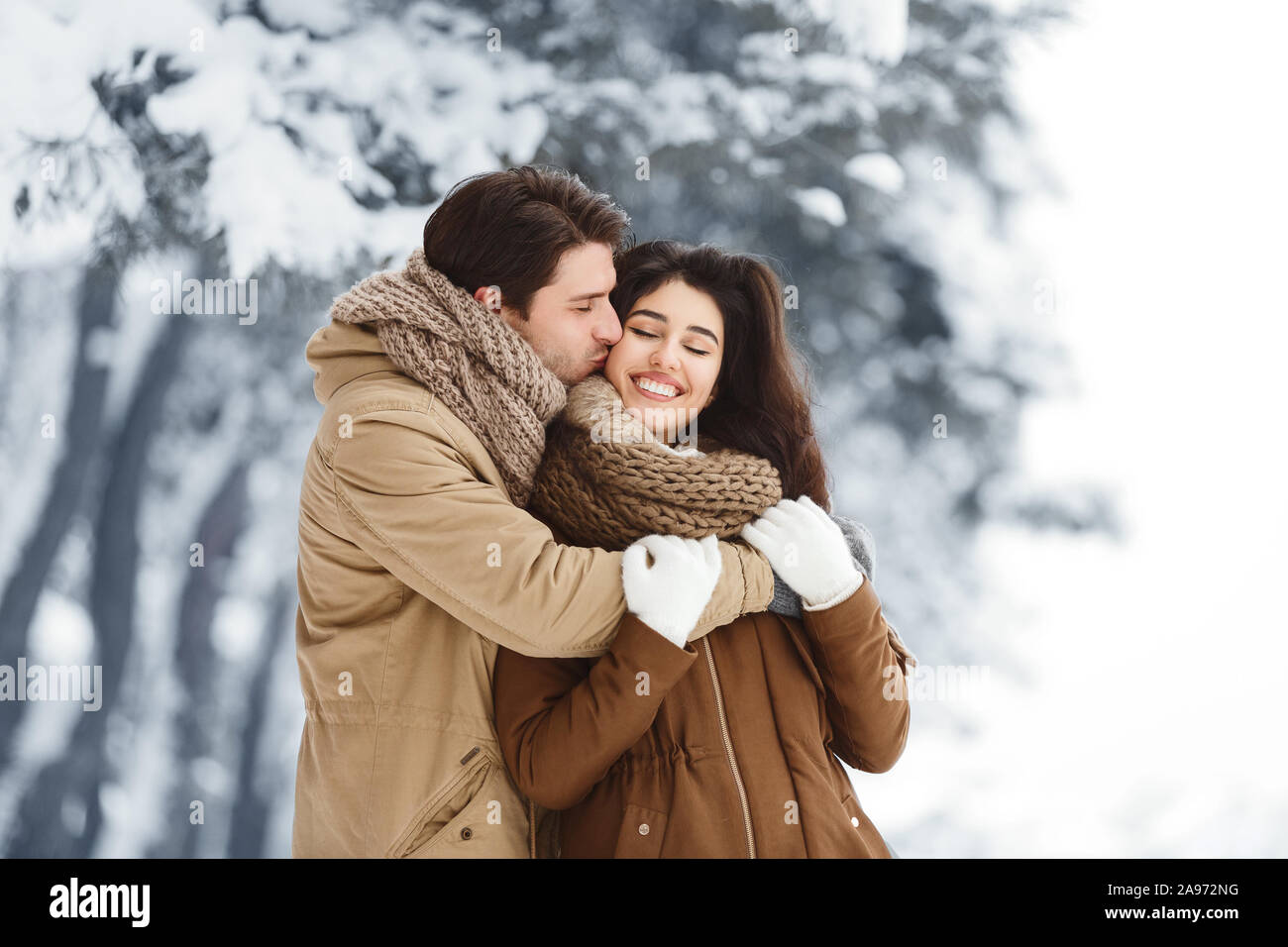 Loving Boyfriend Kissing And Hugging Girlfriend Standing In Snowy ...