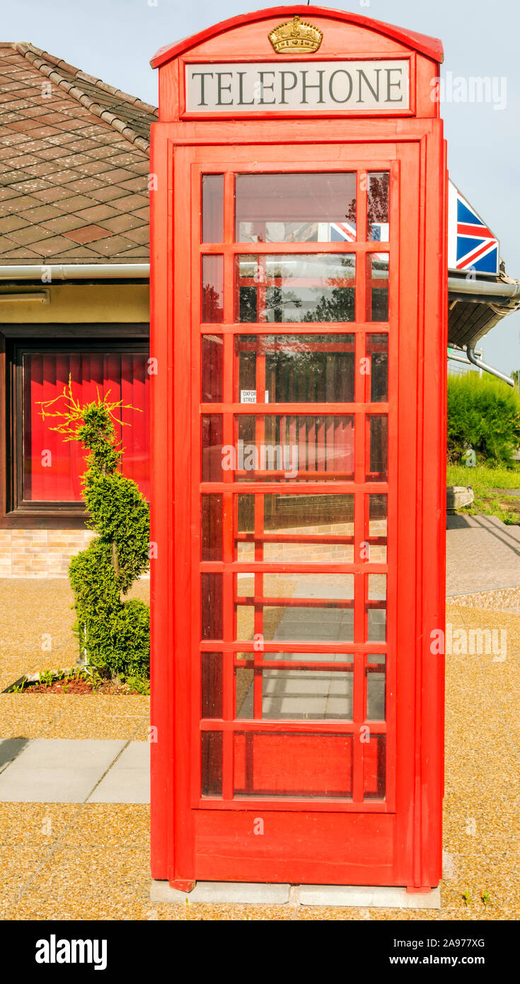 Red telephone booth on the street in a sunny day in London Stock Photo