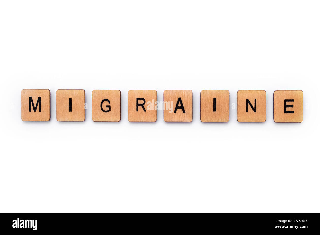 The word MIGRAINE, spelt with wooden letter tiles over a white