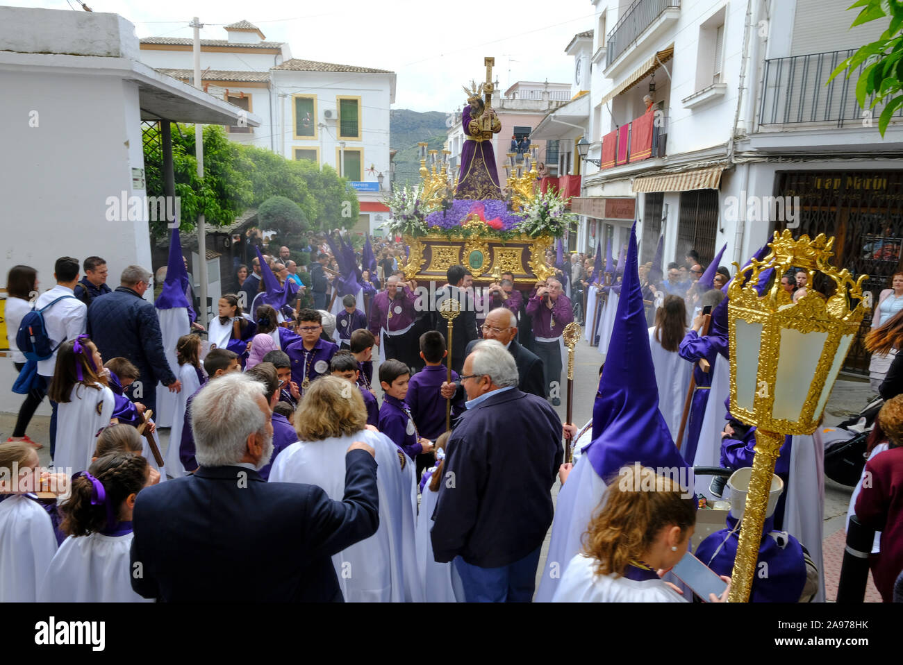 Procession of local community wearing purple capirotes, bearing Jesus and the Cross during Holy Week. Carcabuey, Cordoba Province, Andalucia. Spain Stock Photo