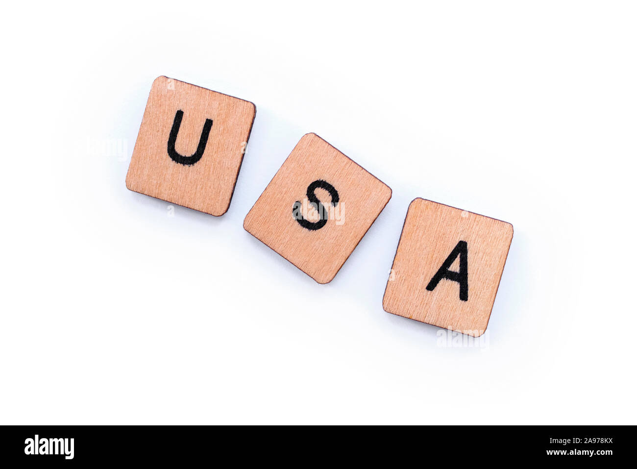 The abbreviation USA - standing for the United States of America, spelt with wooden letter tiles over a white background. Stock Photo