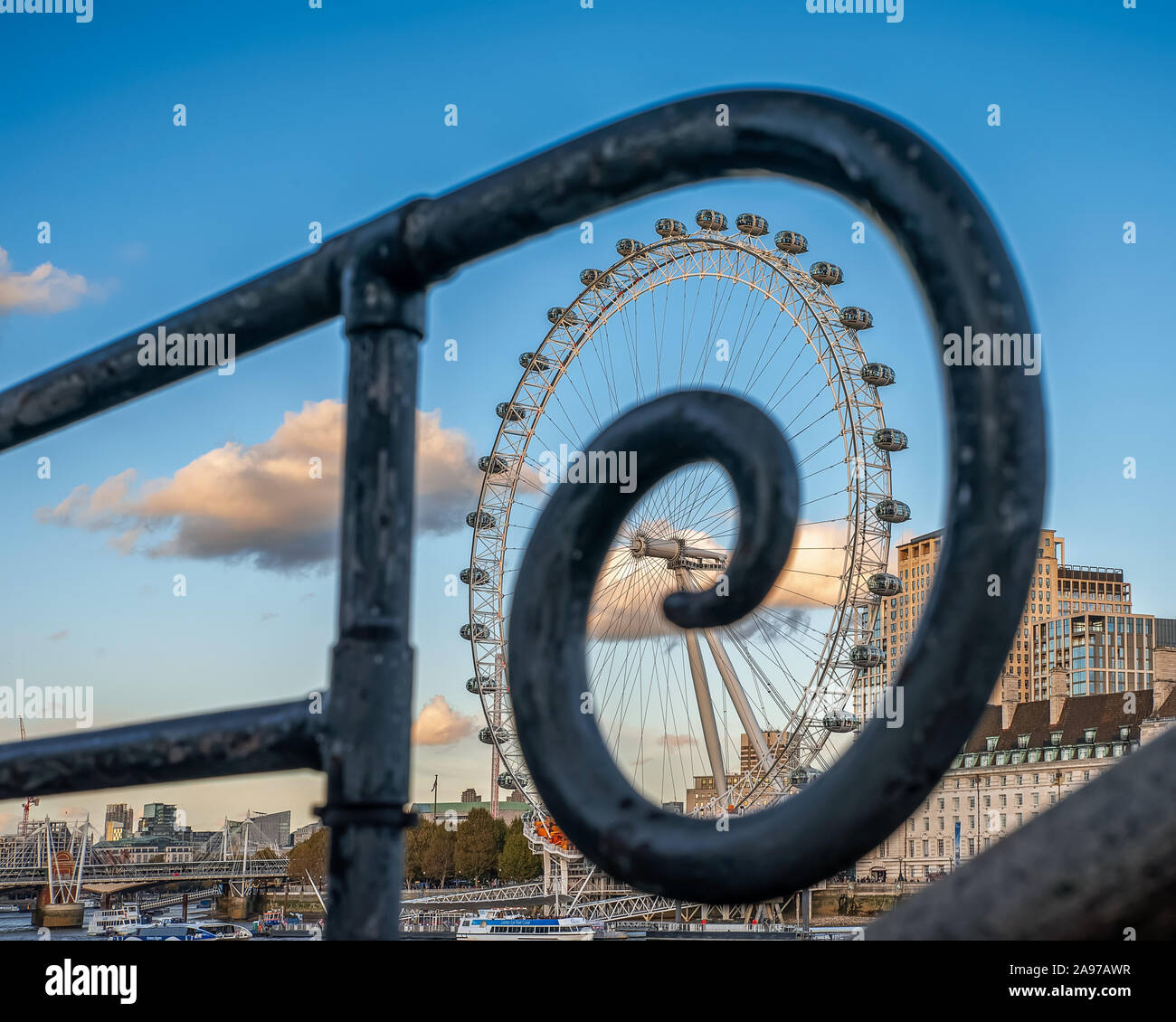 The Coca-cola London eye. The London eye with spiral handrail. Fantastic view, colorful autumn trees and blue sky with clouds. Stock Photo