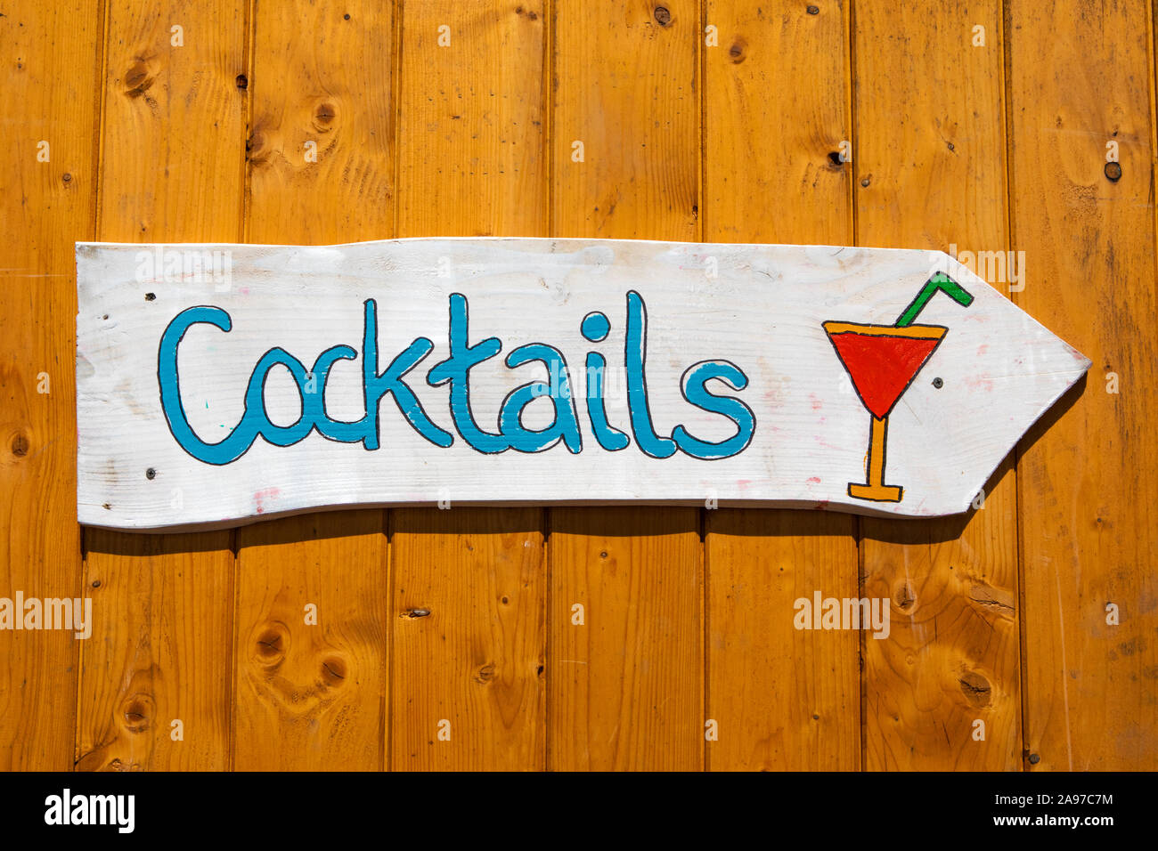 A sign pointing the direction to buy cocktails. Stock Photo