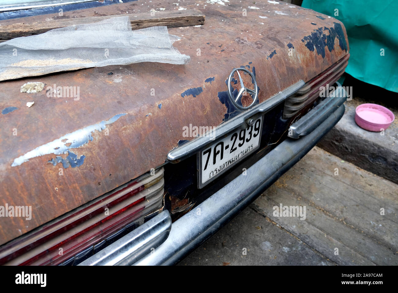 Rear boot-mounted Mercedes 3 Point Star emblem on street- abandoned Mercedes classic car, Bangkok, Thailand Stock Photo