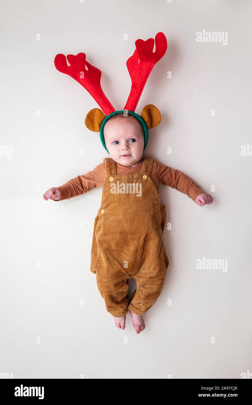 A cute two month old baby wearing festive christmas reindeer antlers Stock Photo