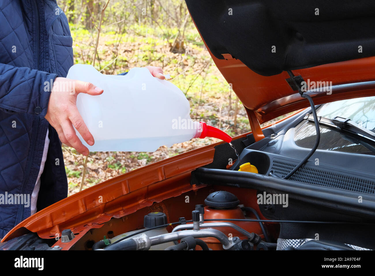 Car maintenance concept. Filling windshield washer fluid on car. Driver