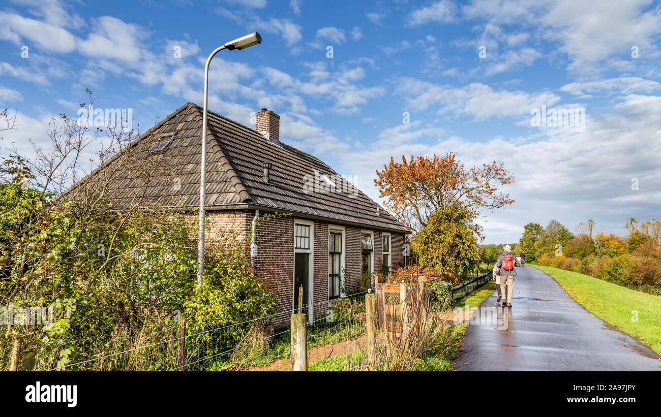Walking along traditional Dutch little dike houses near Zwolle