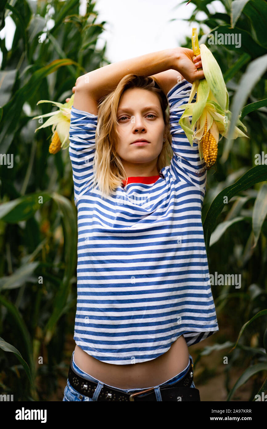 Girl in the corn field. Female picks up corn Stock Photo Alamy