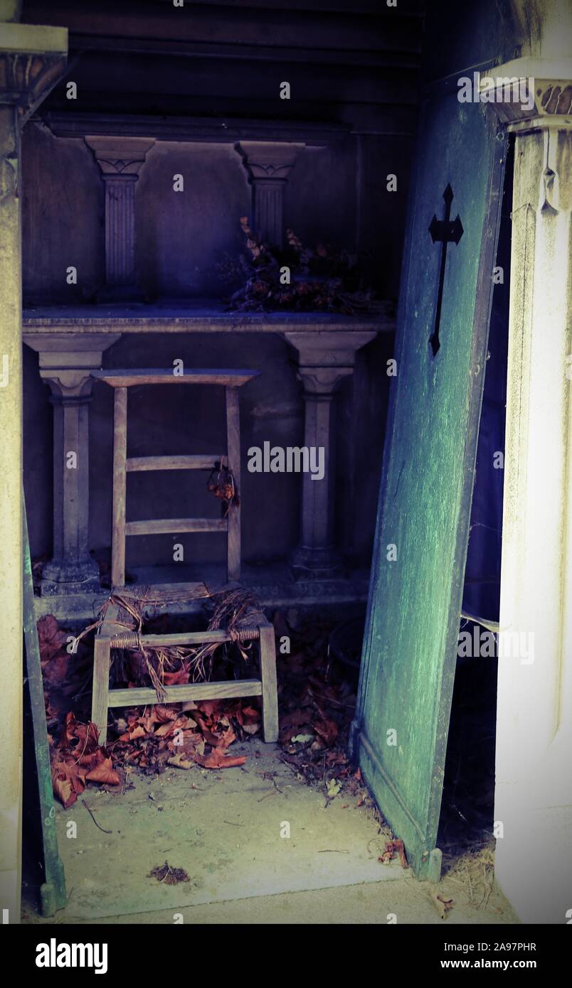broken door and damaged chair on burial plot of the cemetery Stock Photo