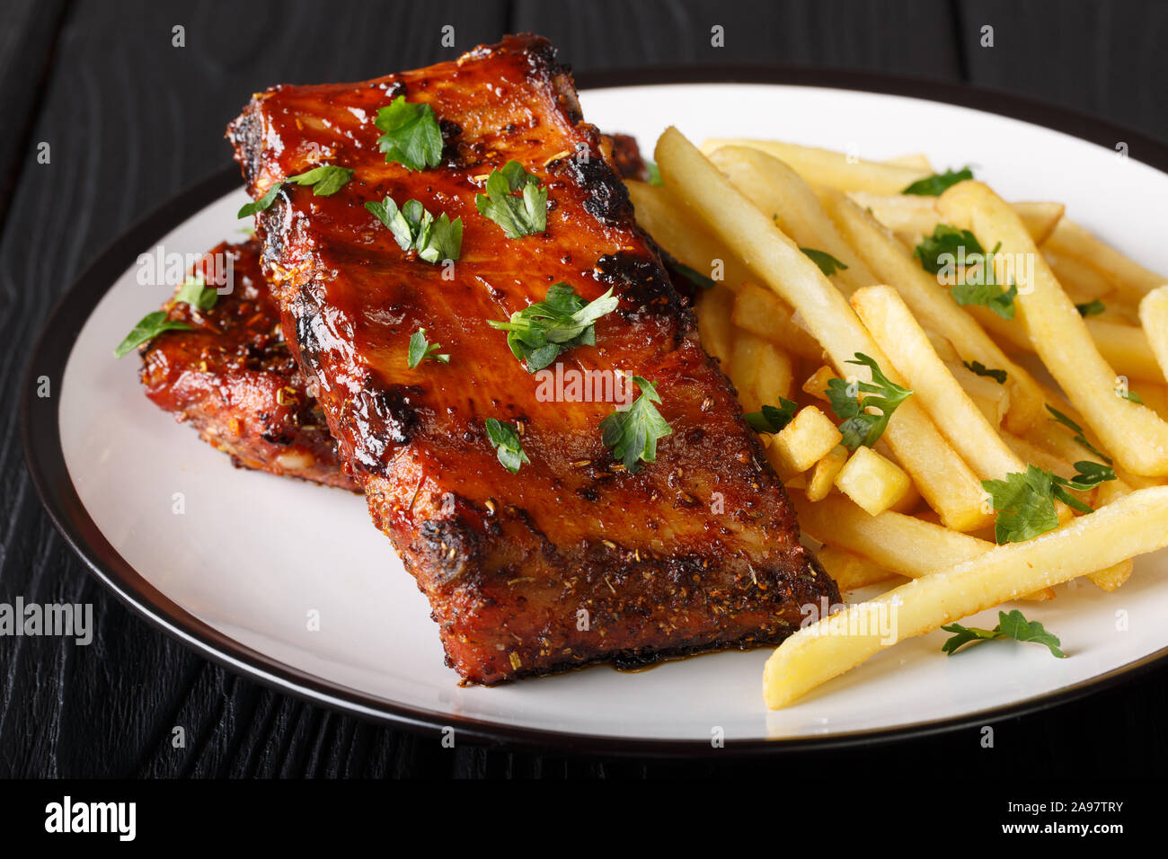 Sticky short ribs with french fries close-up on a plate on the table. horizontal Stock Photo