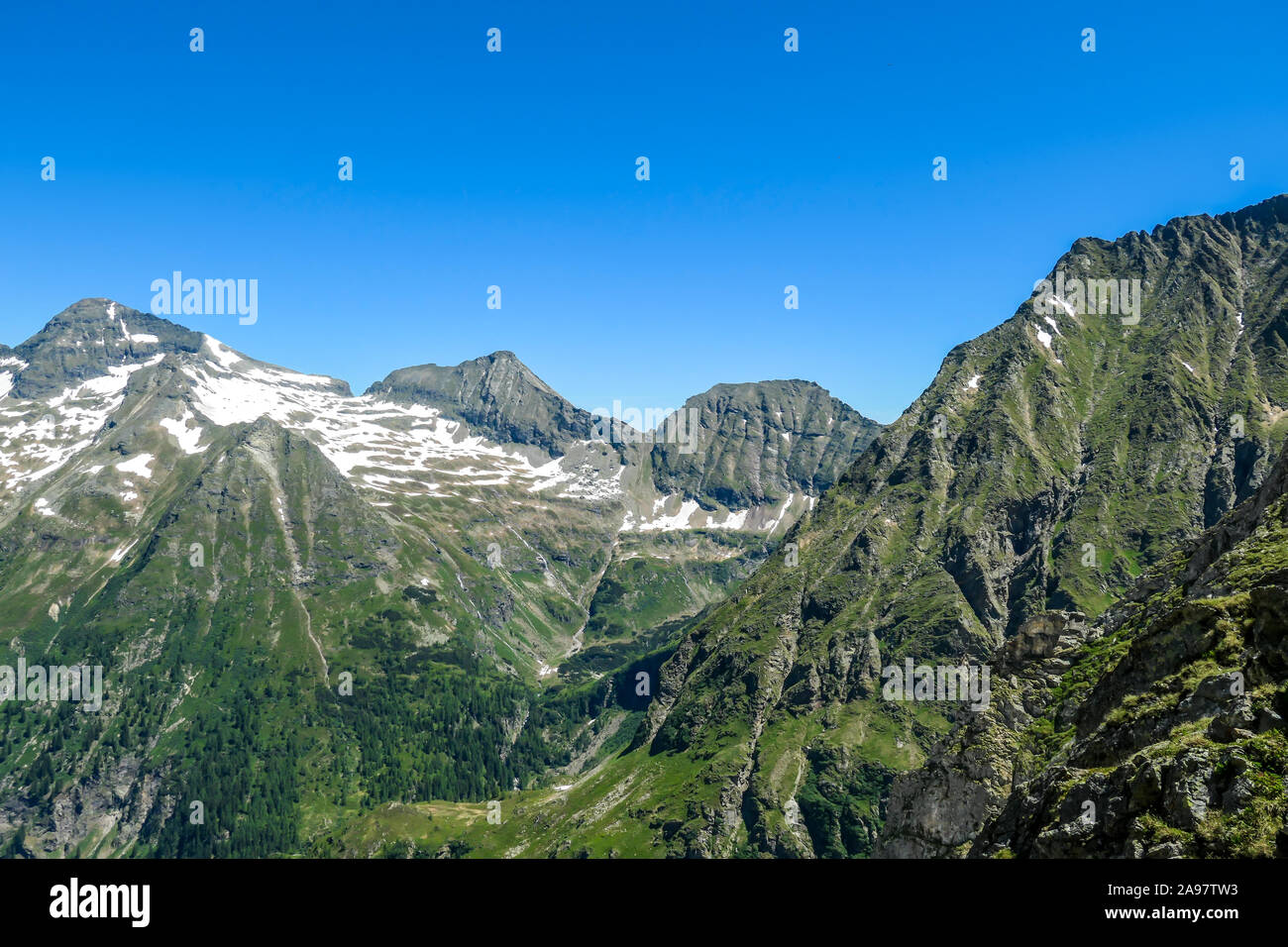 A panoramic view on Schladming Alps, partially still covered with snow. Spring slowly reaching the tallest parts of the mountains. Sharp peaks, slopes Stock Photo