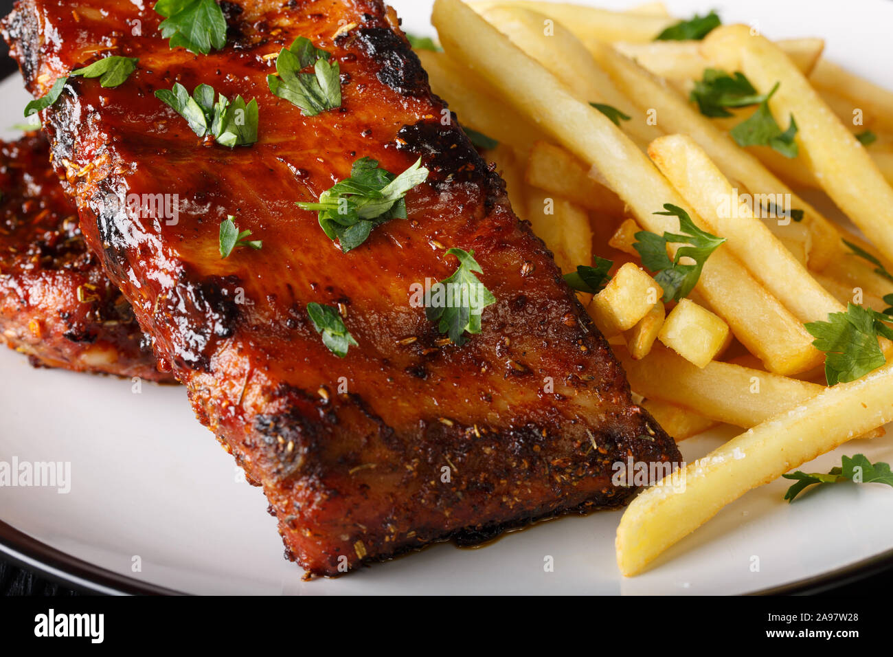 Grilled short ribs served with french fries close-up on a plate on the table. horizontal Stock Photo