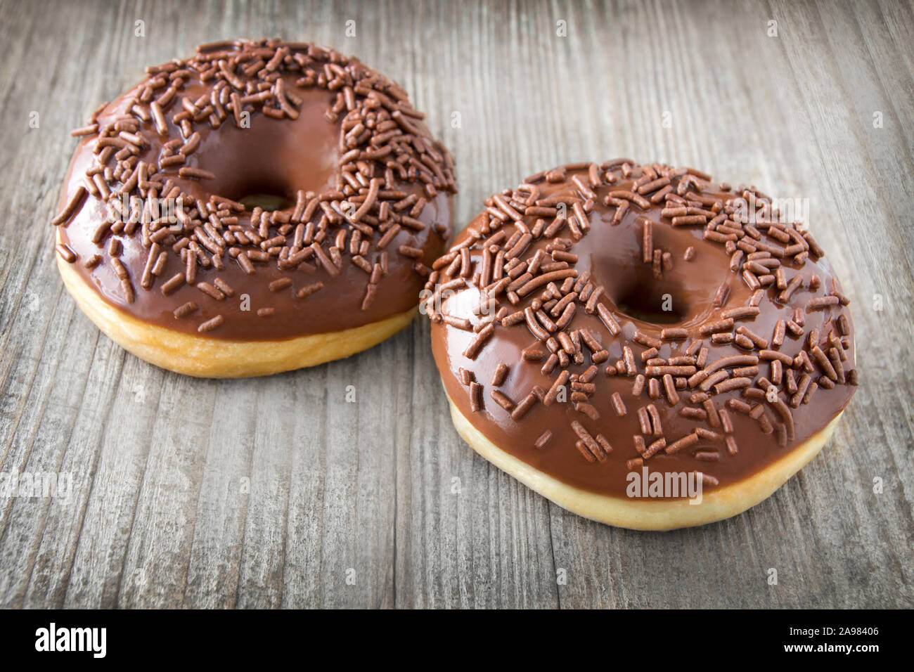 Two Donuts against wooden background Stock Photo