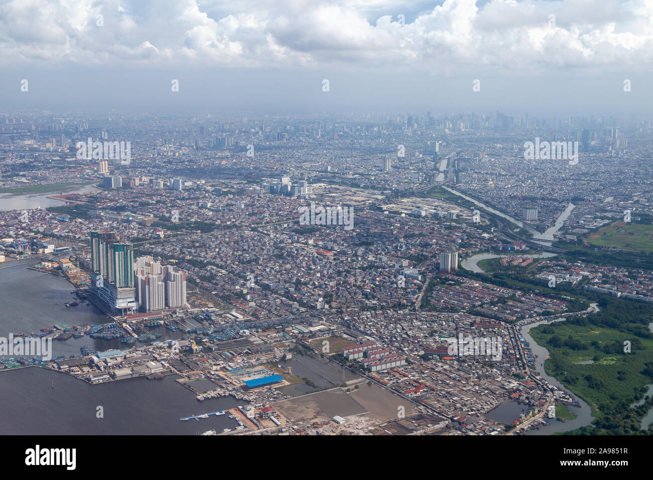 Aerial view of Jakarta. Sunda Kelapa Port can be seen in the lower left corner. Some clouds are visible on this day with high visibility. The central Stock Photo