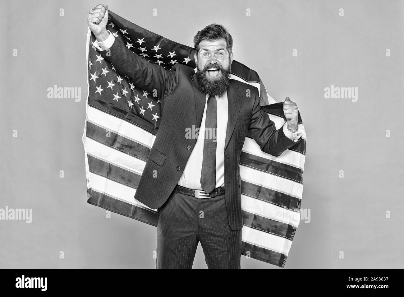 American by birth. Rebel by choice. Confident businessman handsome bearded man in formal suit hold flag USA. Business people. Businessman concept. Successful businessman well groomed appearance. Stock Photo