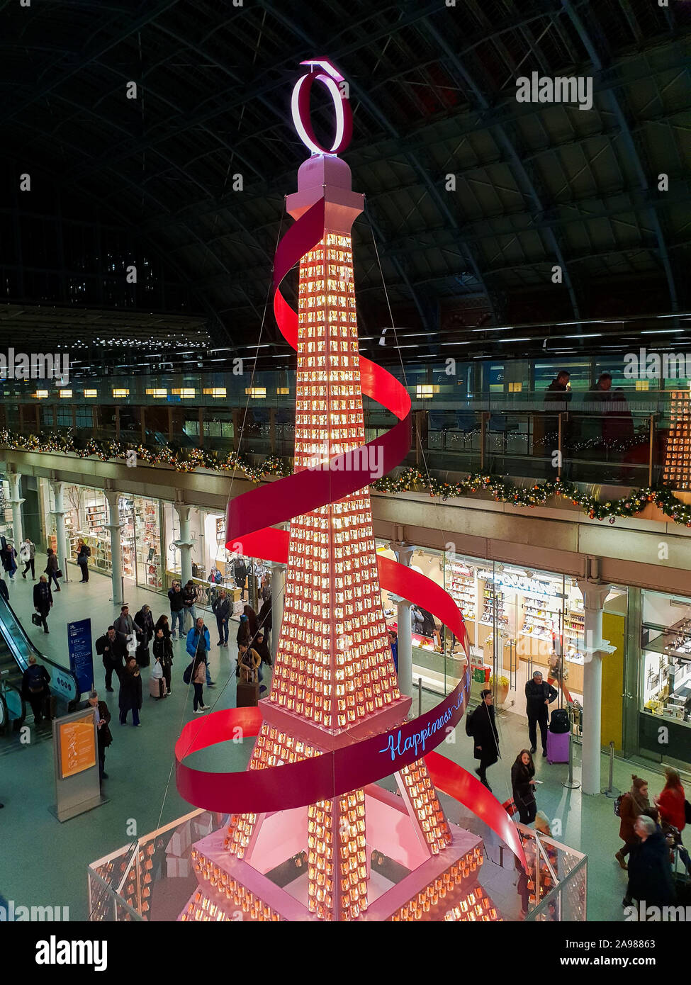 Kings Cross St Pancras. London. UK 13 Nov 2019 - “The Eiffel Tower” installation at Kings Cross St Pancras International rail station. Lancome has teamed up with Kings Cross St Pancras as it unveils its 2019 Christmas installation of Paris’s iconic landmark - The Eiffel Tower. The 36-foot installation embodies the elegance and cheerful spirit of the world’s largest French beauty brand, brightening up the station with Lancôme’s signature pink pantone. Credit: Dinendra Haria/Alamy Live News Stock Photo