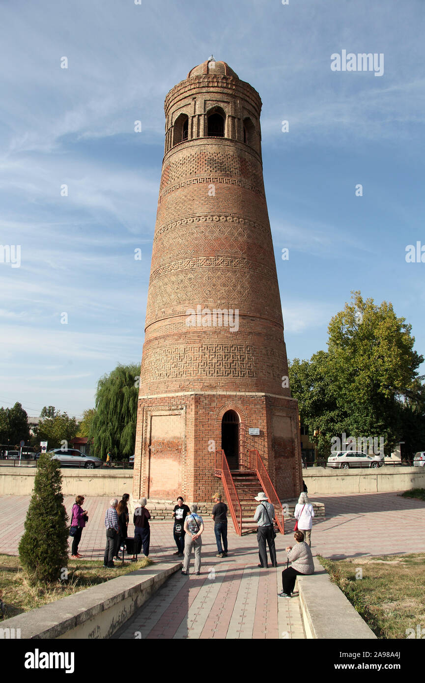 Tourists at Uzgen Minaret Tower in Kyrgyzstan Stock Photo