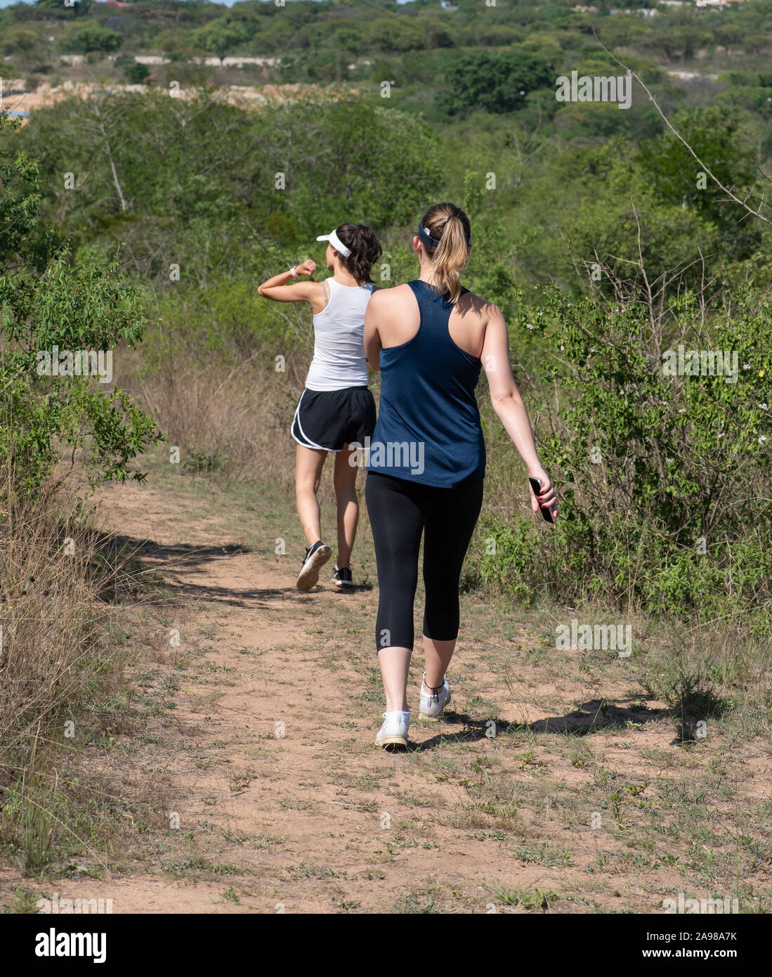 Two young women going for a walk out in nature Stock Photo