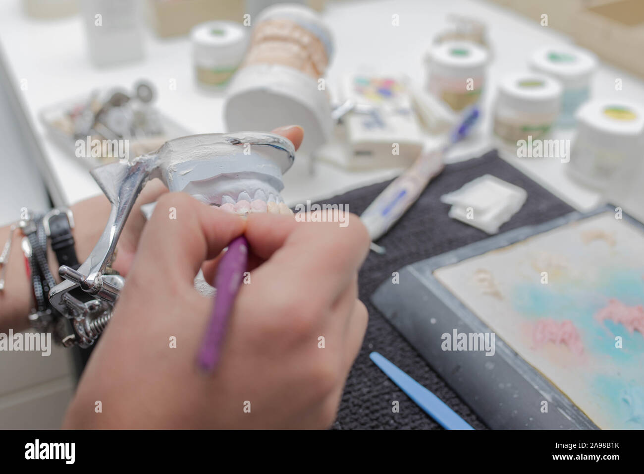 Dental technician working on plaster stone model with zirconium bridge