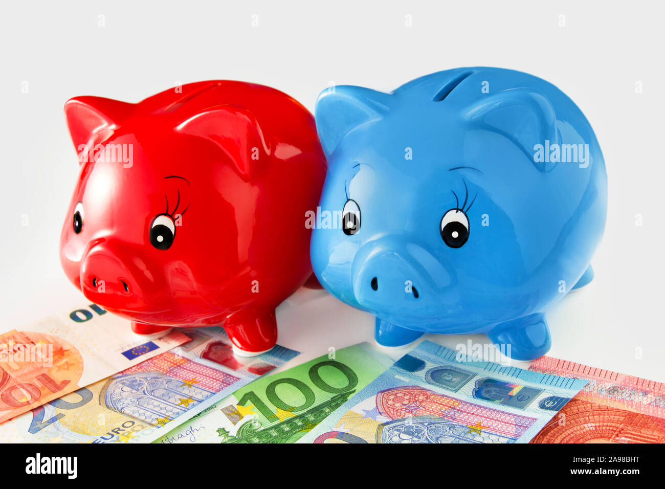 Euro and piggy banks against white background Stock Photo