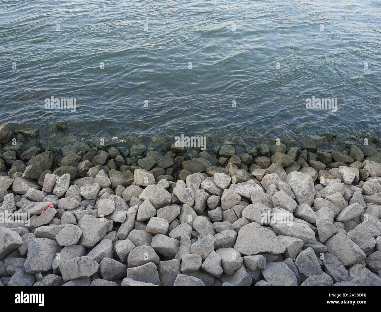 blue water surface with rocks useful as a background Stock Photo - Alamy