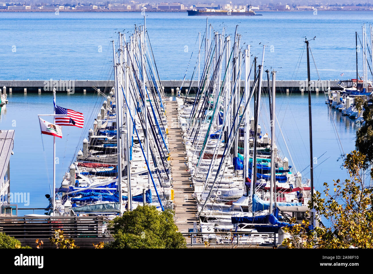 Nov 2, 2019 San Francisco / CA / USA - Boats moored at the South Beach Harbor; the American flag and the California Republic flag waving in the wind Stock Photo