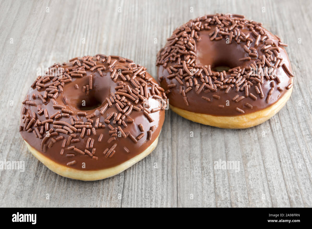 Two Donuts against wooden background Stock Photo
