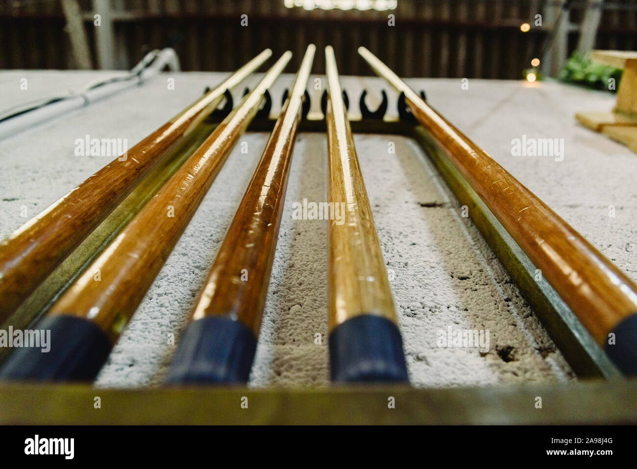 Sticks to play billiards hanging on the wall Stock Photo Alamy