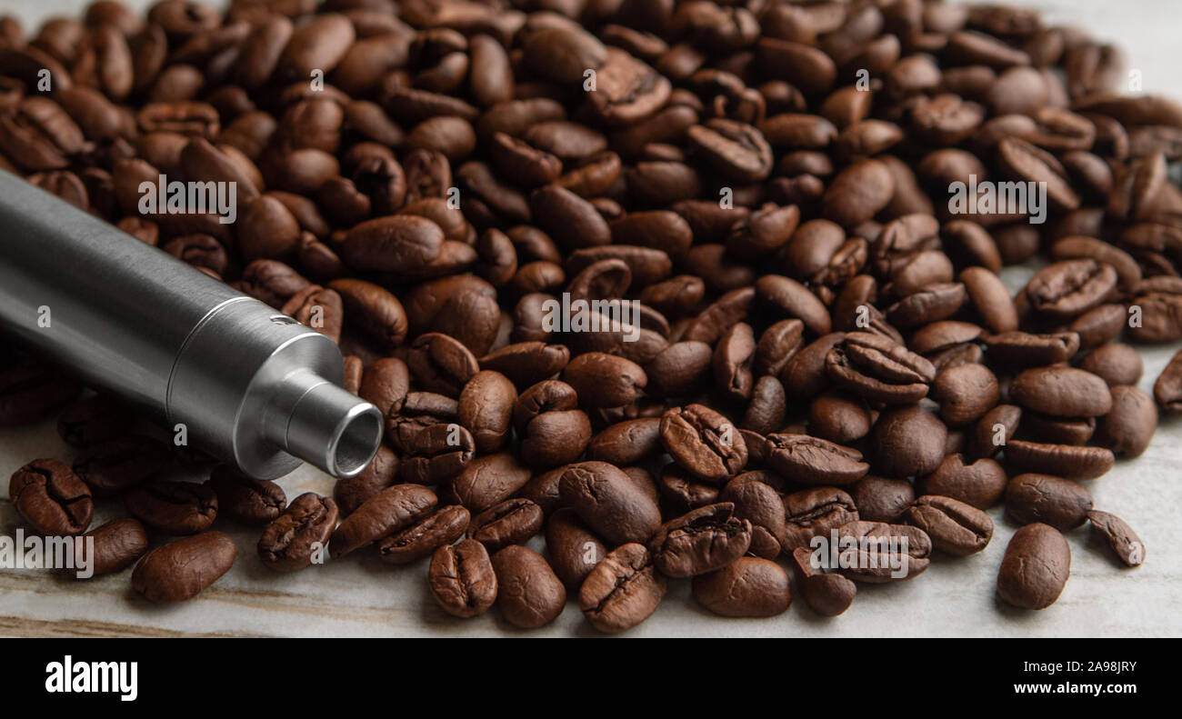 Stainless steel Vape device mod lies on roasted coffee beans Stock Photo