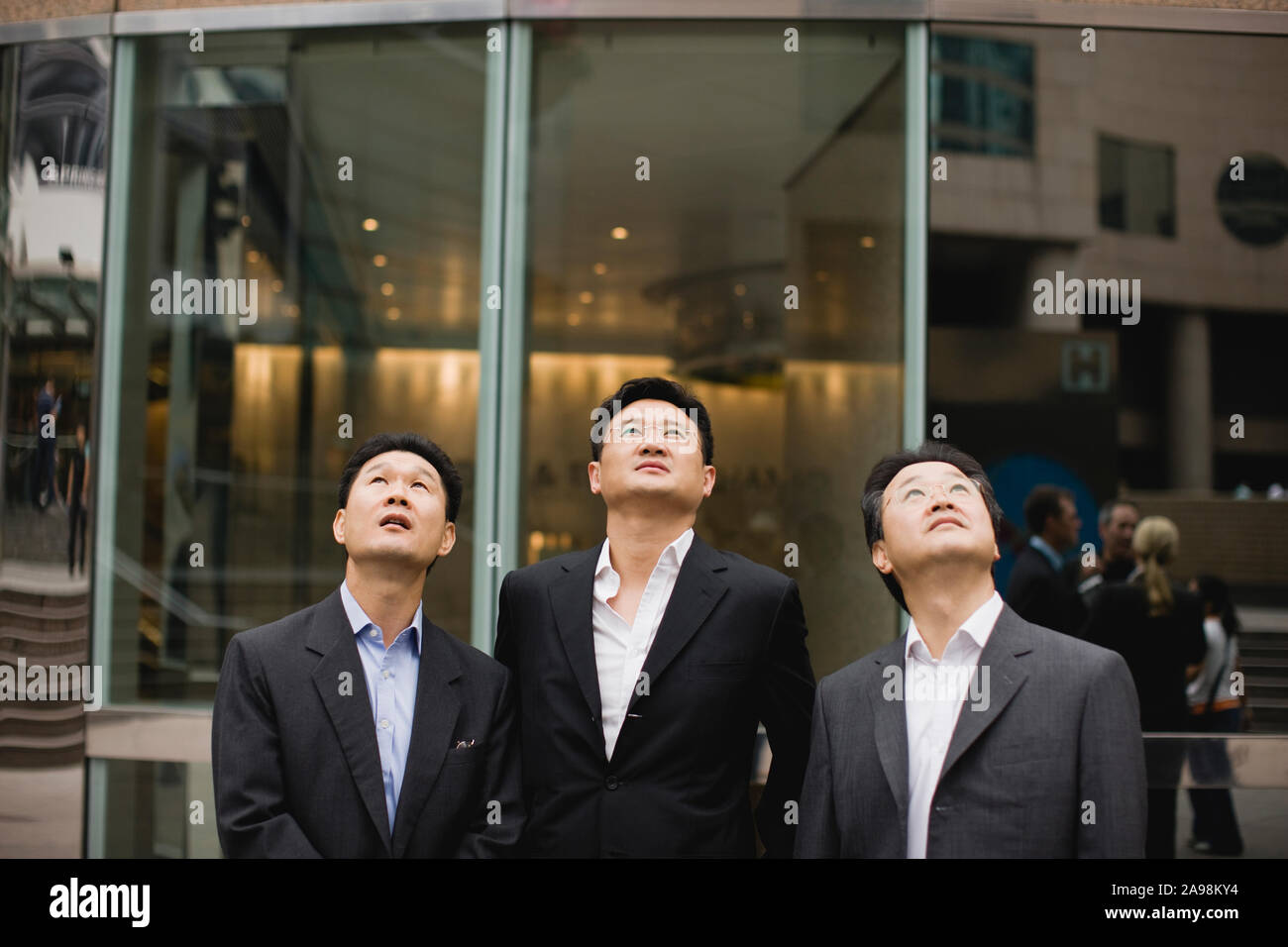 Three businessmen standing next to each other in the city Stock Photo ...