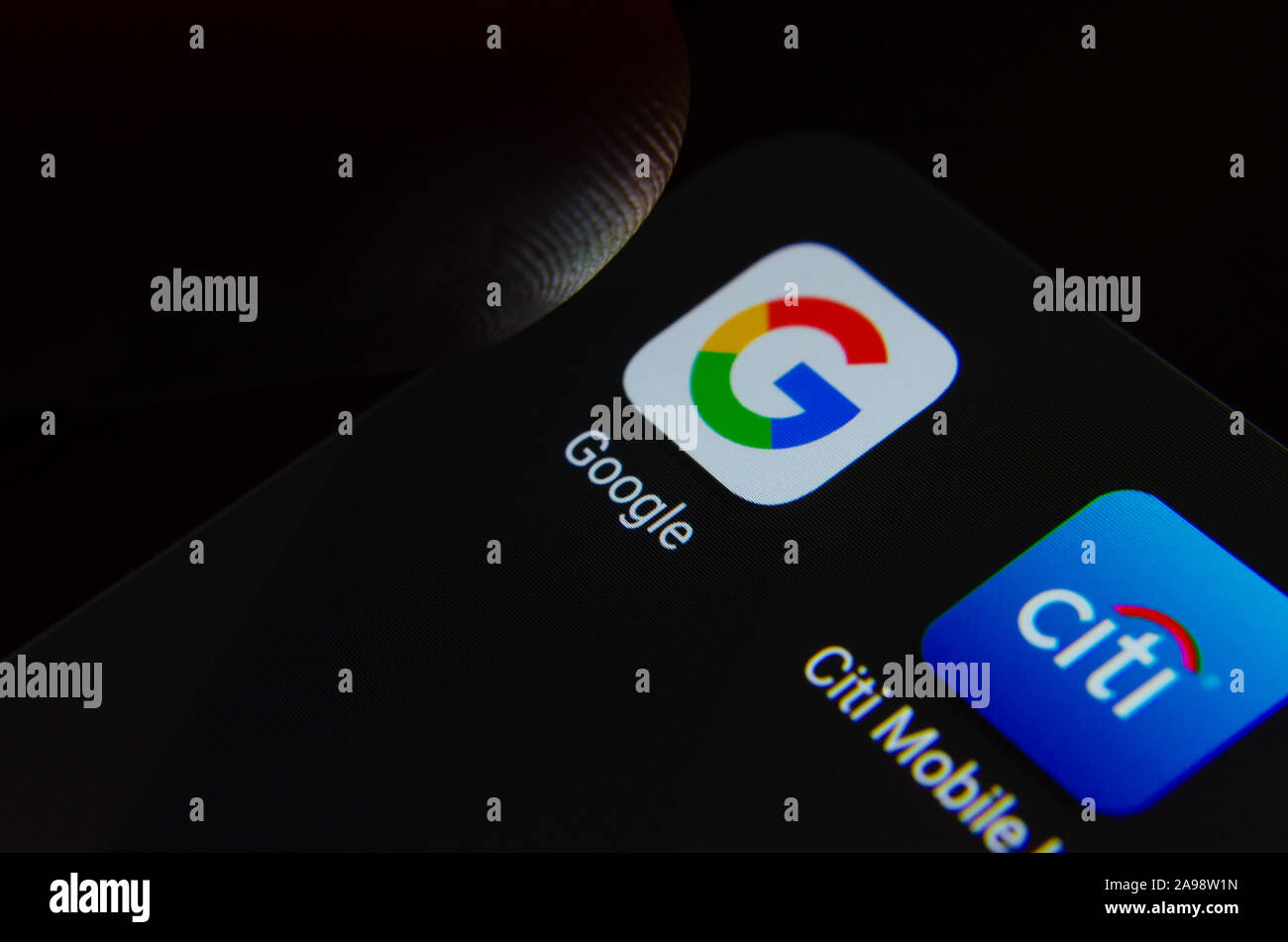 Google and Citibank apps on smartphone screen and a finger over them ready to touch. Macro photo with selective focus. Stock Photo