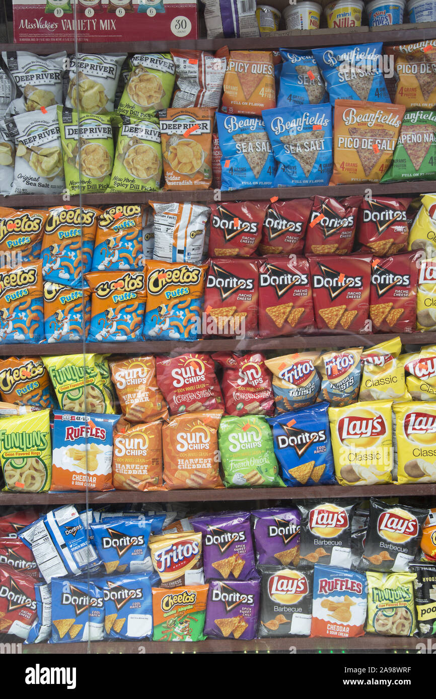 Grocery displays an array of salty chips for sale. Potatie chips are a very popular 'junk food' Stock Photo