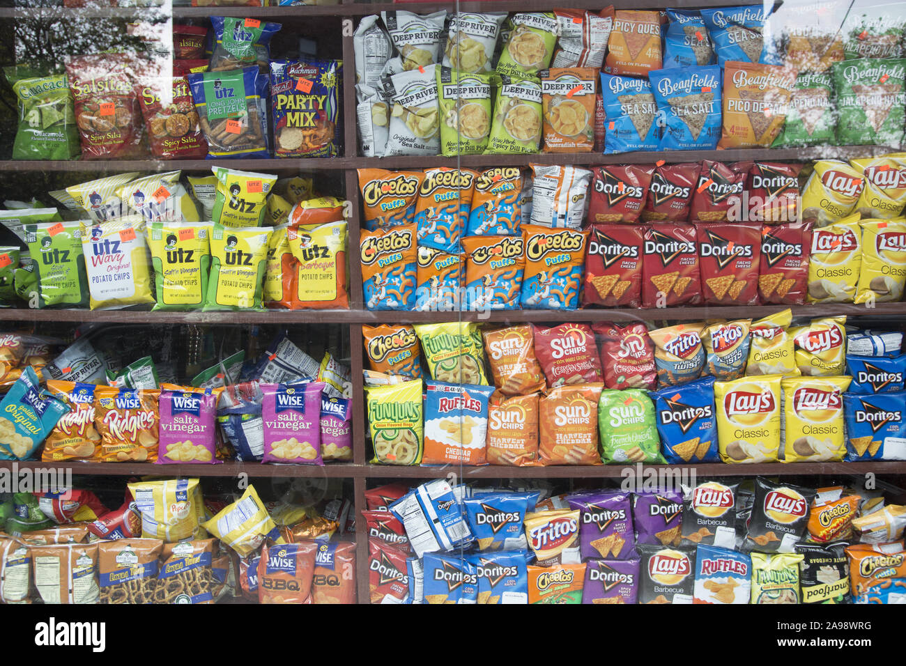Grocery displays an array of salty chips for sale. Potatie chips are a very popular 'junk food' Stock Photo