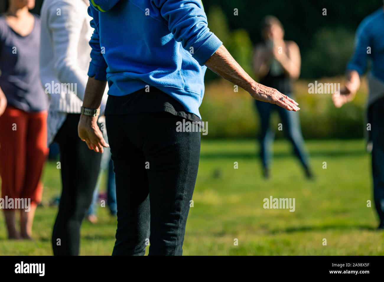 Selective focus of people busy with group activity such as yoga and games  on a grass field in nature outdoors Stock Photo - Alamy