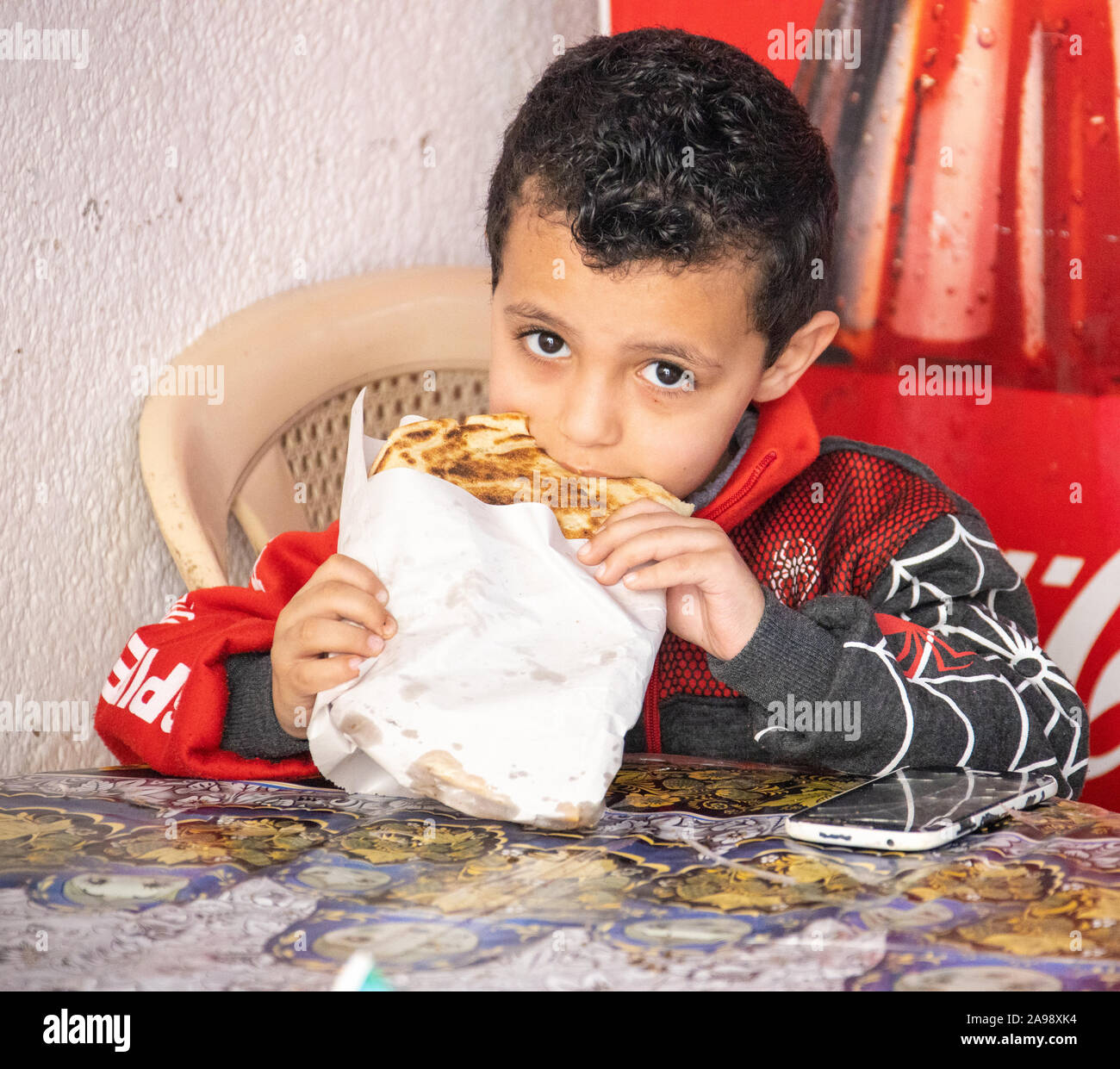 Local boy eating in the Souk Area, Sidon (Saida), Lebanon Stock Photo