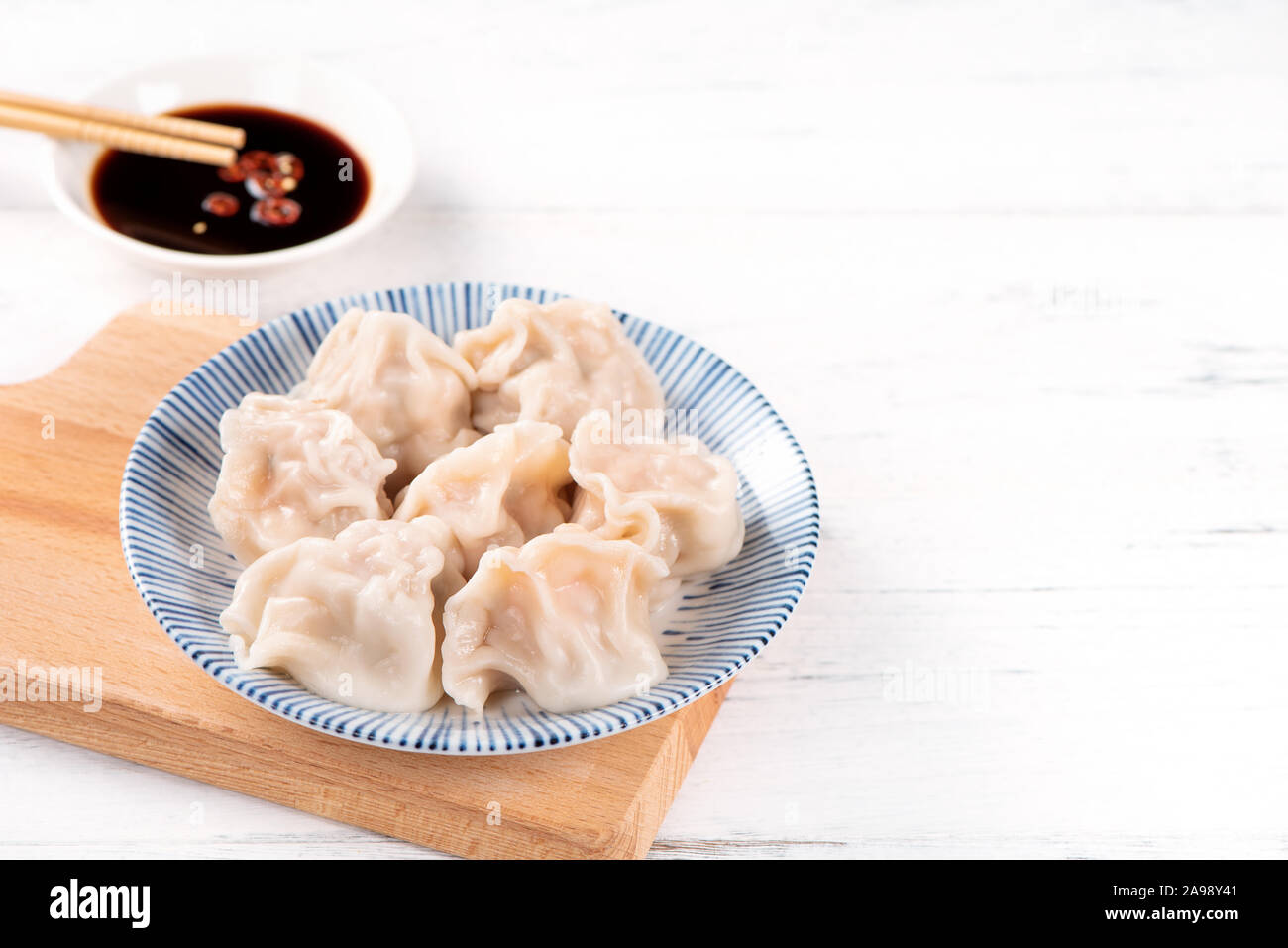 Fresh, delicious boiled pork, shrimp gyoza dumplings on white background  with soy sauce and chopsticks, close up, lifestyle. Homemade design concept  Stock Photo - Alamy