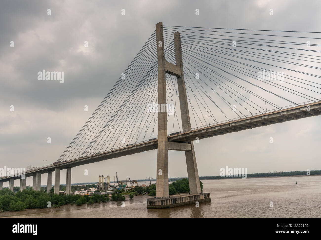 Ho Chi Minh City, Vietnam - March 12, 2019: Long Tau and song Sai Gon rivers meeting point. Landscape with  H-shaped pylon of Phu My suspension bridge Stock Photo