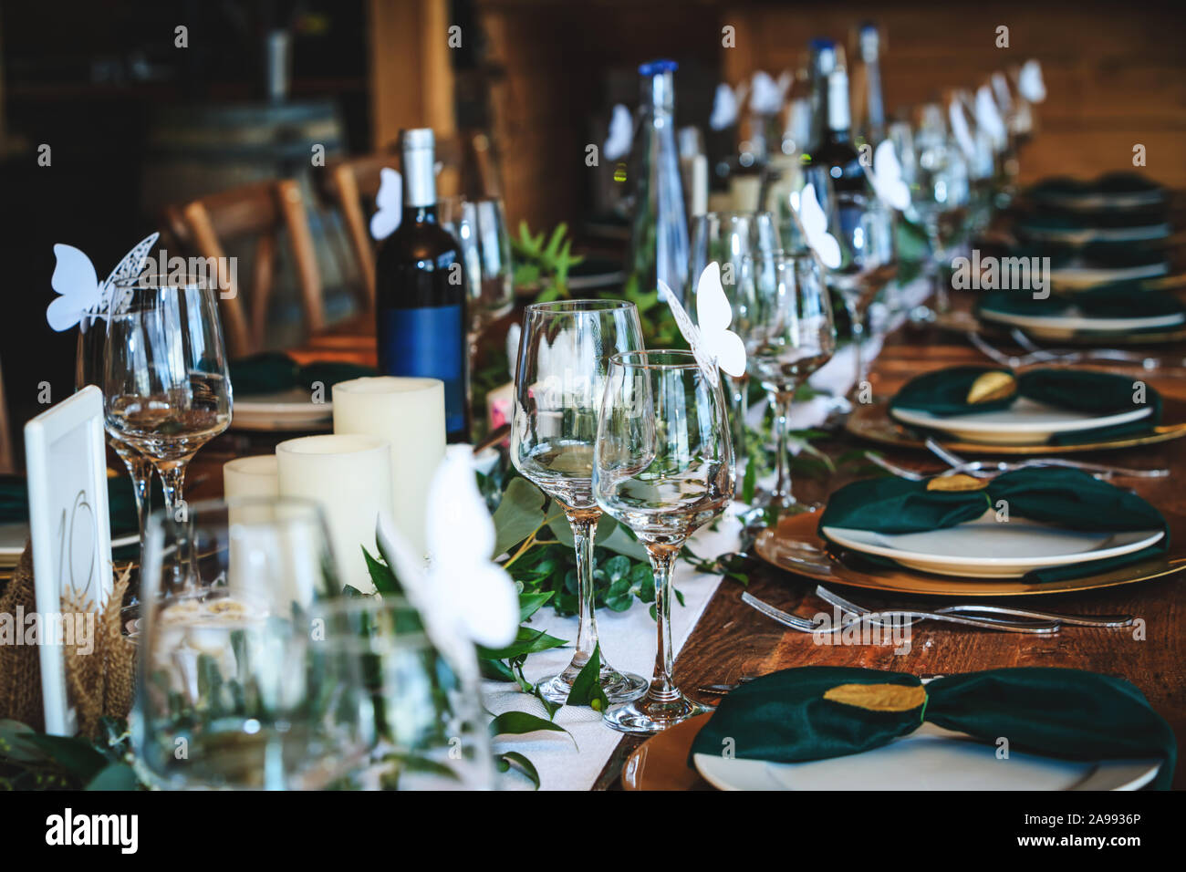 Wine glasses, plates, forks and green briefcases for the banquet. Rustic  wedding table setting in fancy Canadian restaurant. Vintage decoration of  rec Stock Photo - Alamy