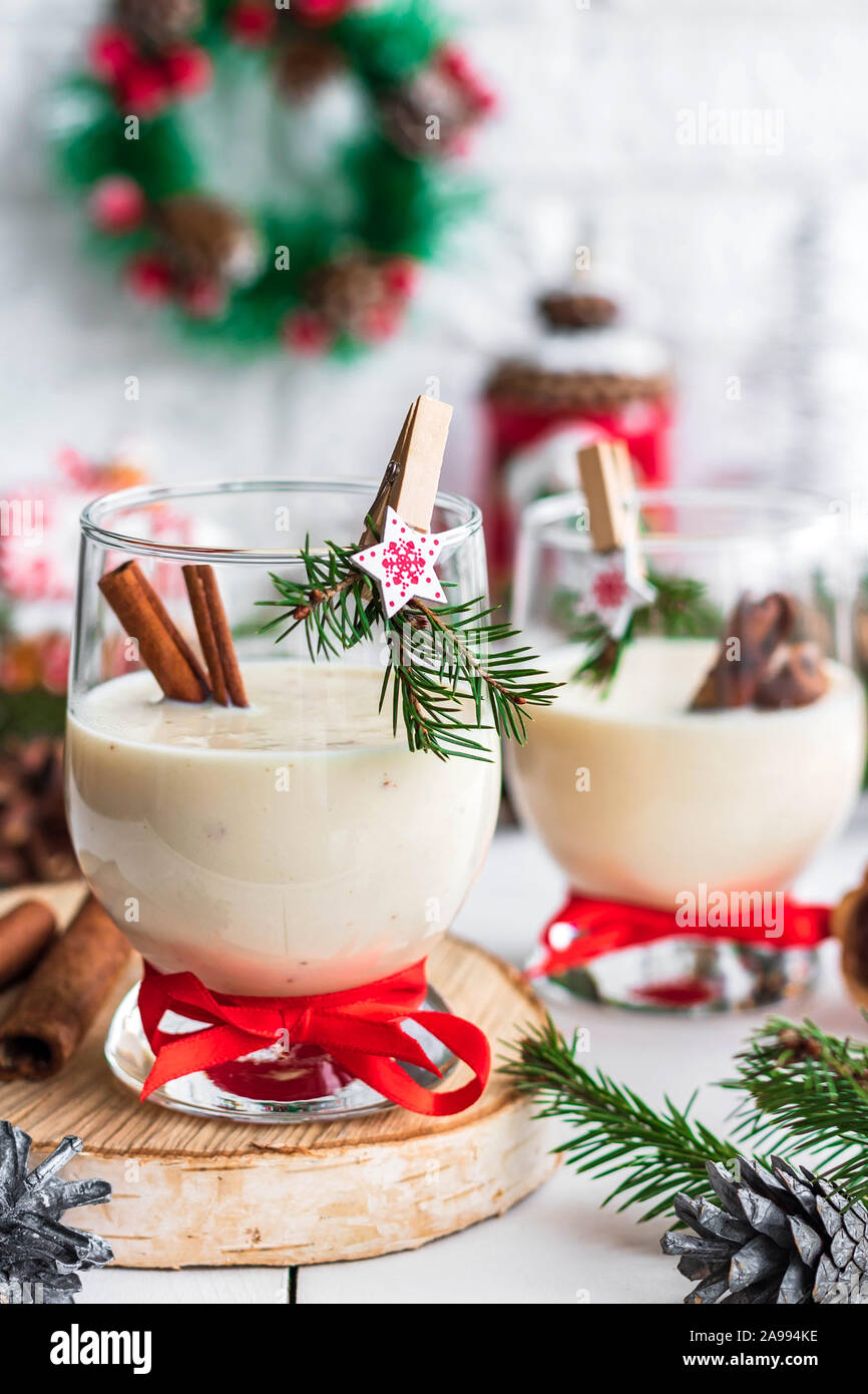 A traditional eggnog Christmas drink in a glass goblet decorated with New Year clothespin. Non-alcoholic option. Atmospheric photos. Stock Photo
