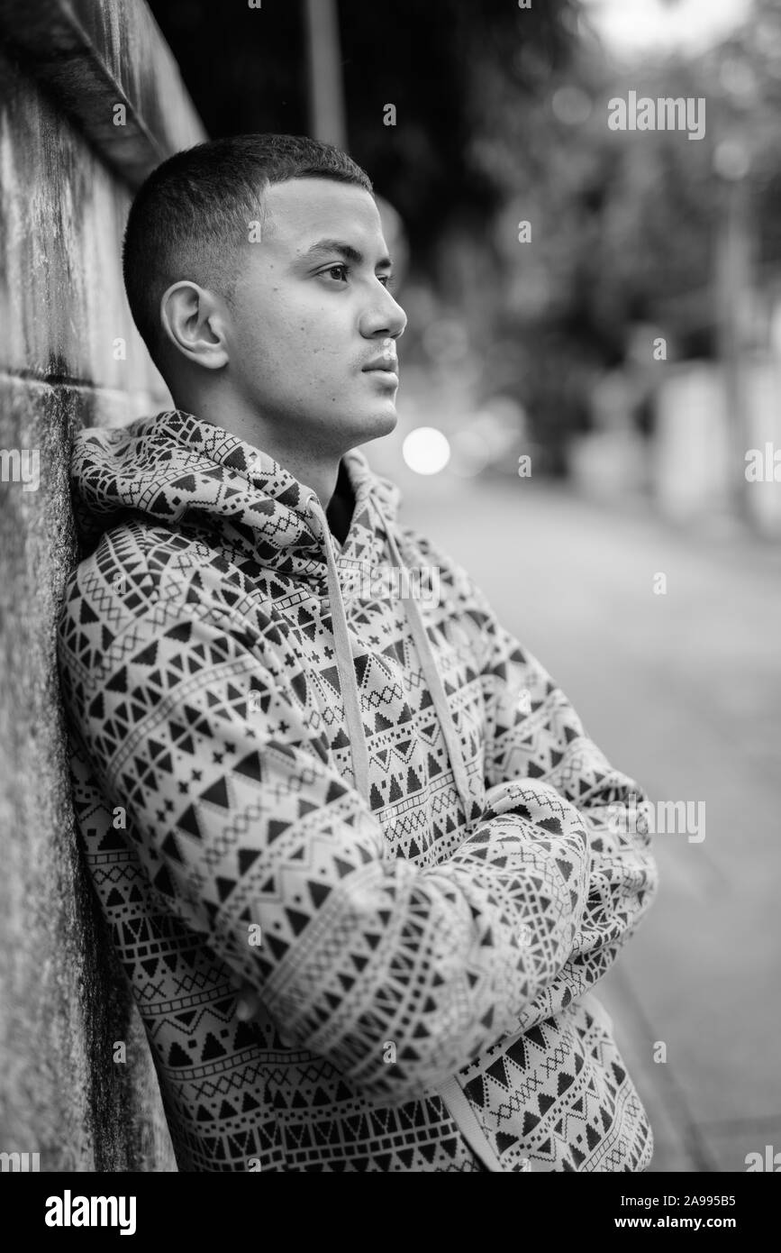 Young multi ethnic Asian man outdoors in black and white Stock Photo