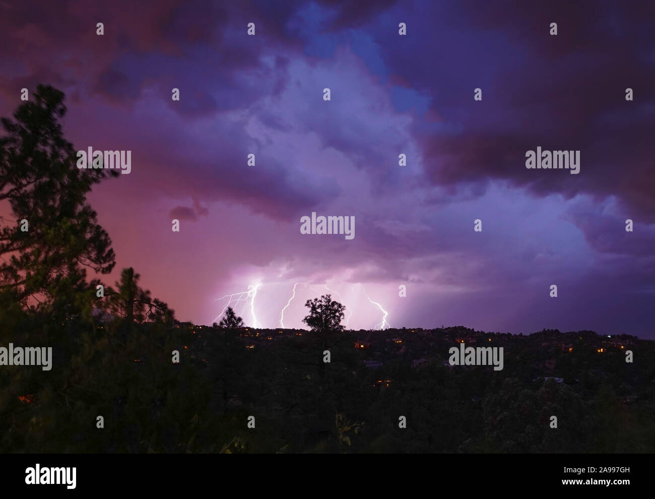 A monsoon lightning storm hits Arizona right after sunset, and accents the dramatic sky's colors. Stock Photo