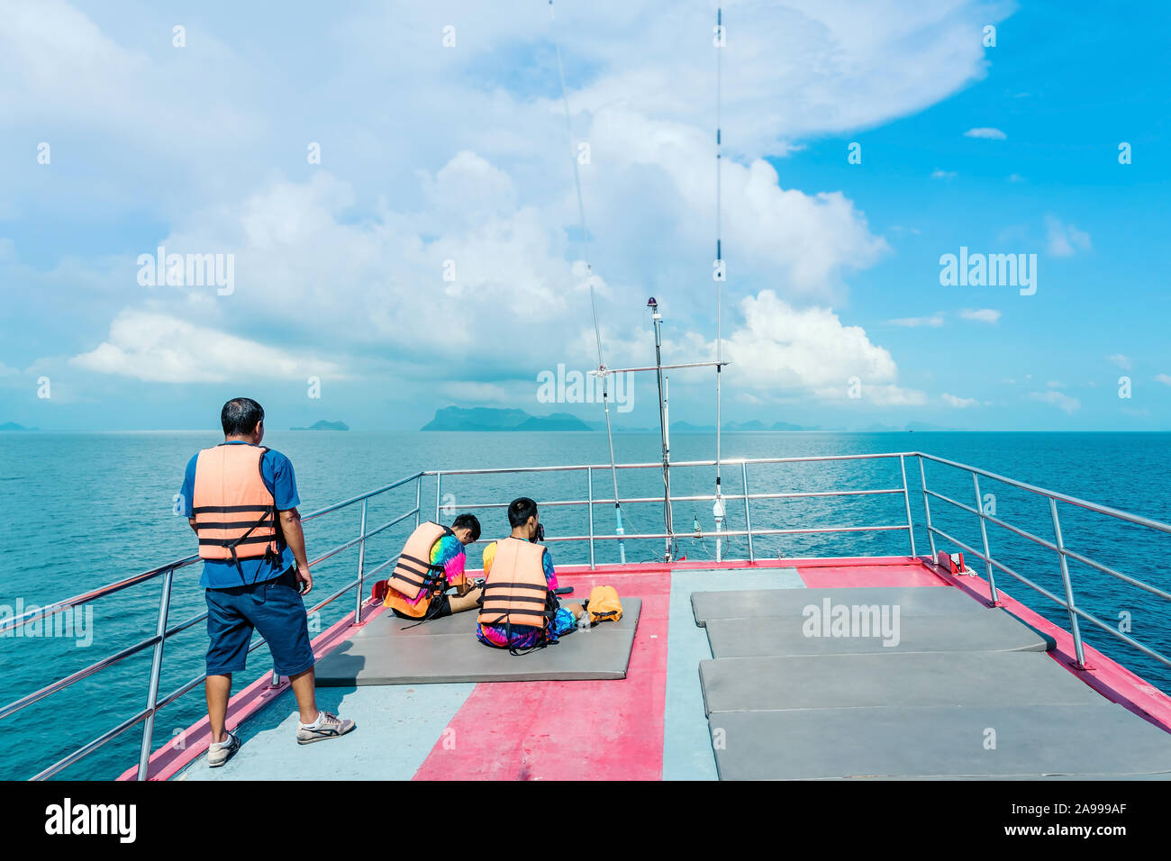 Tourists relaxing on boat deck and looking to the beautiful tropical ...