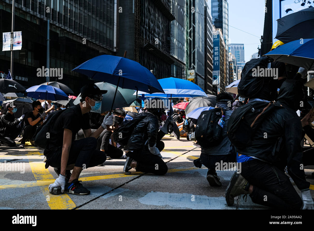 Hong Kong, China. 13th Nov, 2019. Protestors put up umbrella as a shield during a protest in the Central district Hong Kong. A 'Blossom Everywhere' action was organized by the protestors to paralyze traffic and vandalize things across Hong Kong for its third consecutive days and have sparked some of the worst violence in five months of unrest. Credit: SOPA Images Limited/Alamy Live News Stock Photo