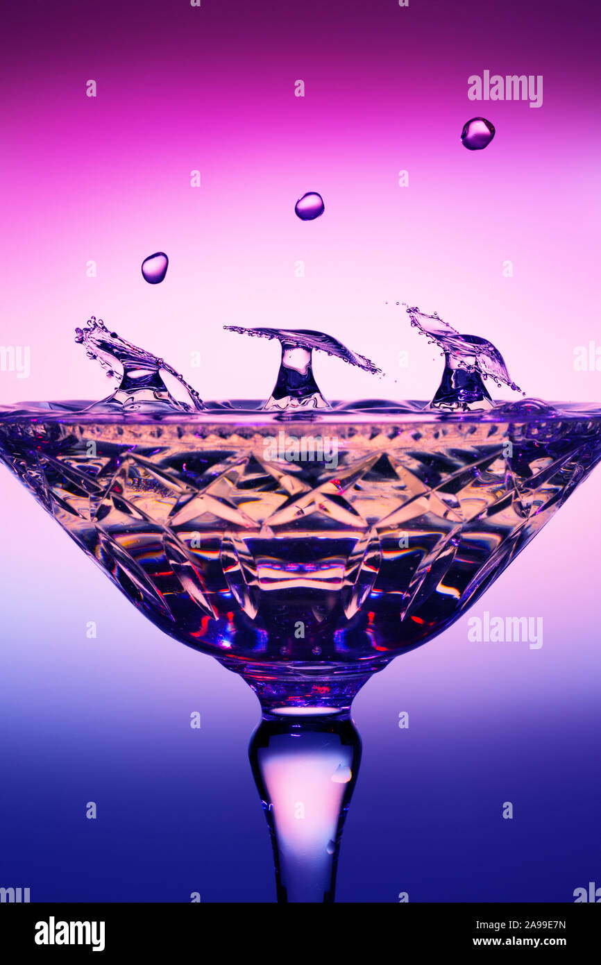 A trio of water drop collisions forming umbrellas in a champagne glass